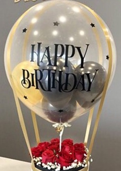 1 bubble transparent balloon with happy birthday print and gold balloons inside with led lights and a box of red roses