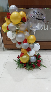 Transparent Balloon Printed Happy Birthday with gold silver and white balloon arch decorated with red gerbera flowers basket