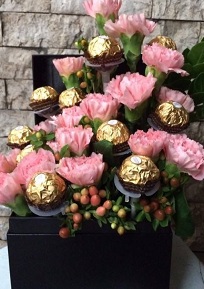 15 pink flowers and 16 ferroro chocolates arranged in a black box