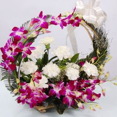 5 orchids with 6 carnations in basket and handle arrangement