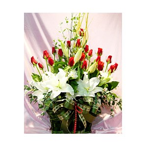 white lilies and red roses in a basket