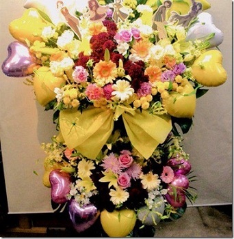 Large Arrangement in 2 tier of Yellow flowers and balloons with ribbons and roses inserted in between the balloons Approx 3 to 4 feet
