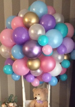 25 Balloon bouquet in mix colors tied to a basket with 6 inches teddy sitting inside