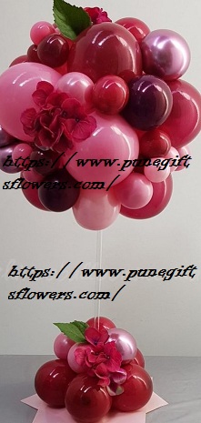 Decorated small and large ballloons 30 shades of red balloons at bottom with shades of red balloons on top of stick 