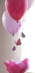 3 pink balloons on sticks with 3 butterflies with for decoration on stick arranged in a box with ribbons