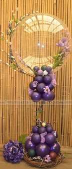 Bobo balloon with trailing orchids and purple balloons in basket