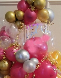 Transparent stuffed balloon with small and large dark pink silver and golden balloons garland decorated with ribbons and flowers