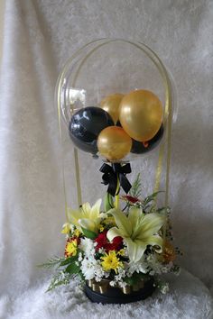 Clear Balloon with 2 black 2 Gold balloons inside with 3 white Lilies and 10 White Red Carnations Basket