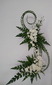 Inverted S with 2 tier of White flowers and thin cut palm leaves
