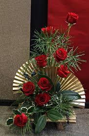 12 red roses wrapped with gold paper fans in a basket