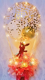 Golden confetti inside the transparent balloon tied to a box with 8 ferrero rocher chocolates in red net with string lights