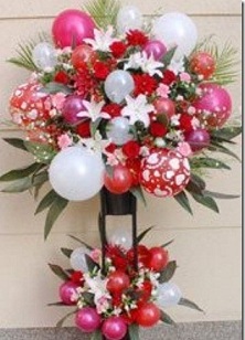 Large Arrangement in 2 tier of Red flowers Lilies and balloons with ribbons and roses inserted in between the balloons Approx 3 to 4 feet