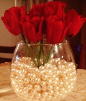 Beads in a glass bowl with 6 red roses