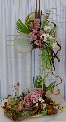 Arrangement of pink roses about 3 feet with Jute coveringat base and Rounded Jute cloth with ribbons and drooping leaves