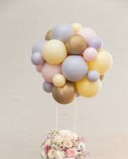 Cluster of balloons on sticks attached to assorted flowers basket
